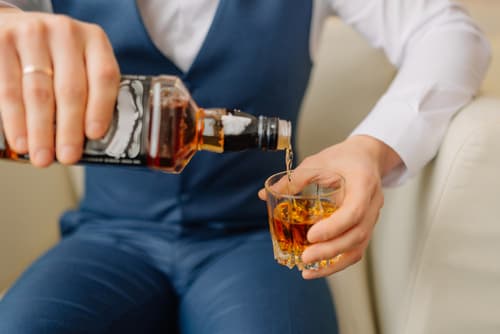 Man in suit pouring drink