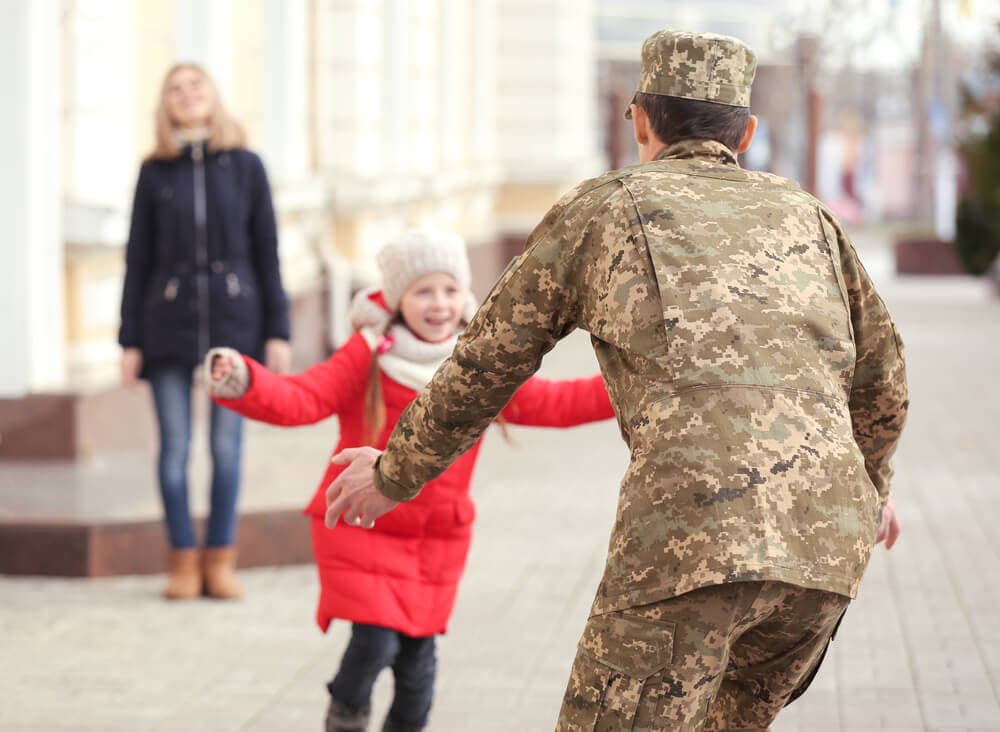 young girl running to her military father