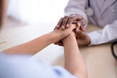 doctor holding the hands of a patient and comforting them during medical detox for drugs or alcohol